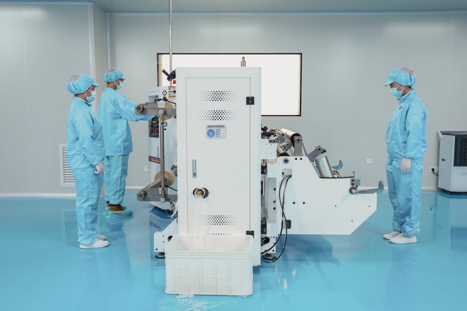 Cleanroom operators running master-roll slitting and rewinding machine for oil blotting paper