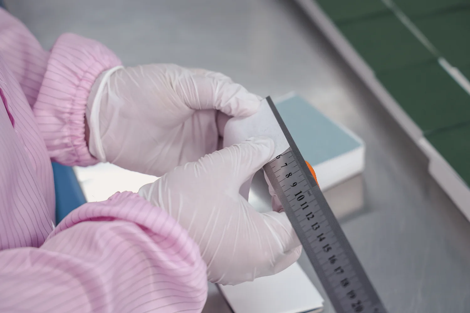 IPQC inspector verifying oil blotting paper sheet tolerance with steel ruler
